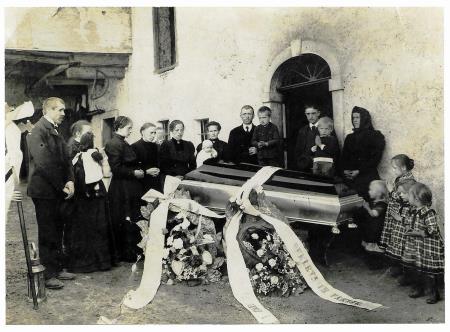 Pogreb Frančiška Želeta 1916. Na sredi stojita stari oče Ivan in oče Frenk, , z otrokom Frančiška Novak Žele. Četrta z leve stoji Katarina Žele, roj. Novak, otroka na robu vrat sta Frenk in Toni.